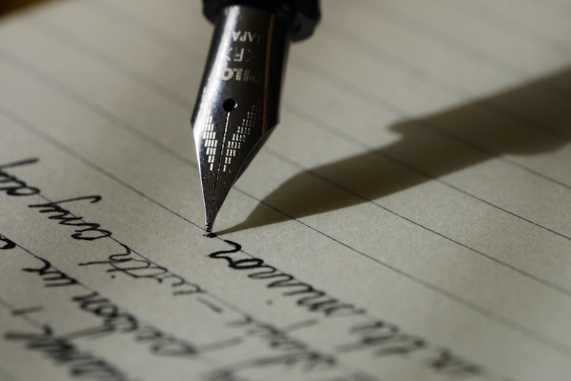 An open notebook and pen on a calm desk beside a window
